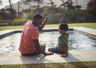 Smiling,Father,And,Son,Giving,High,Five,To,Each,Other